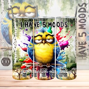 Pode incluir: Um copo branco com um design colorido que apresenta um pássaro de desenho animado com o texto "I Have 5 Moods". O pássaro está empoleirado em um galho com respingos de tinta coloridos no fundo. O texto no copo diz "I'm too old for this", "I'm too tired for this", "I don't have time for this", "I'm too sober for this", e "I don't get paid enough for this".