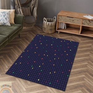 Peut inclure: Un tapis bleu foncé avec un motif de 1 et de 0 colorés, ressemblant à du code binaire. Le tapis est posé sur un sol en bois dur avec un motif en chevron.