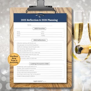 May include: A wooden clipboard holds a New Year's reflection and planning worksheet for 2025 and 2026. The worksheet includes sections for favorites, reflections, and future goals. Two champagne flutes and a bottle are in the background.