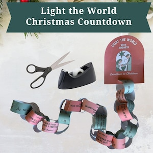 May include: A Christmas countdown craft kit with scissors, tape dispenser, and paper chain links. The kit includes a red card with the text "Light the World with Kindness" and a Christmas nativity scene. The banner reads "Light the World Christmas Countdown."