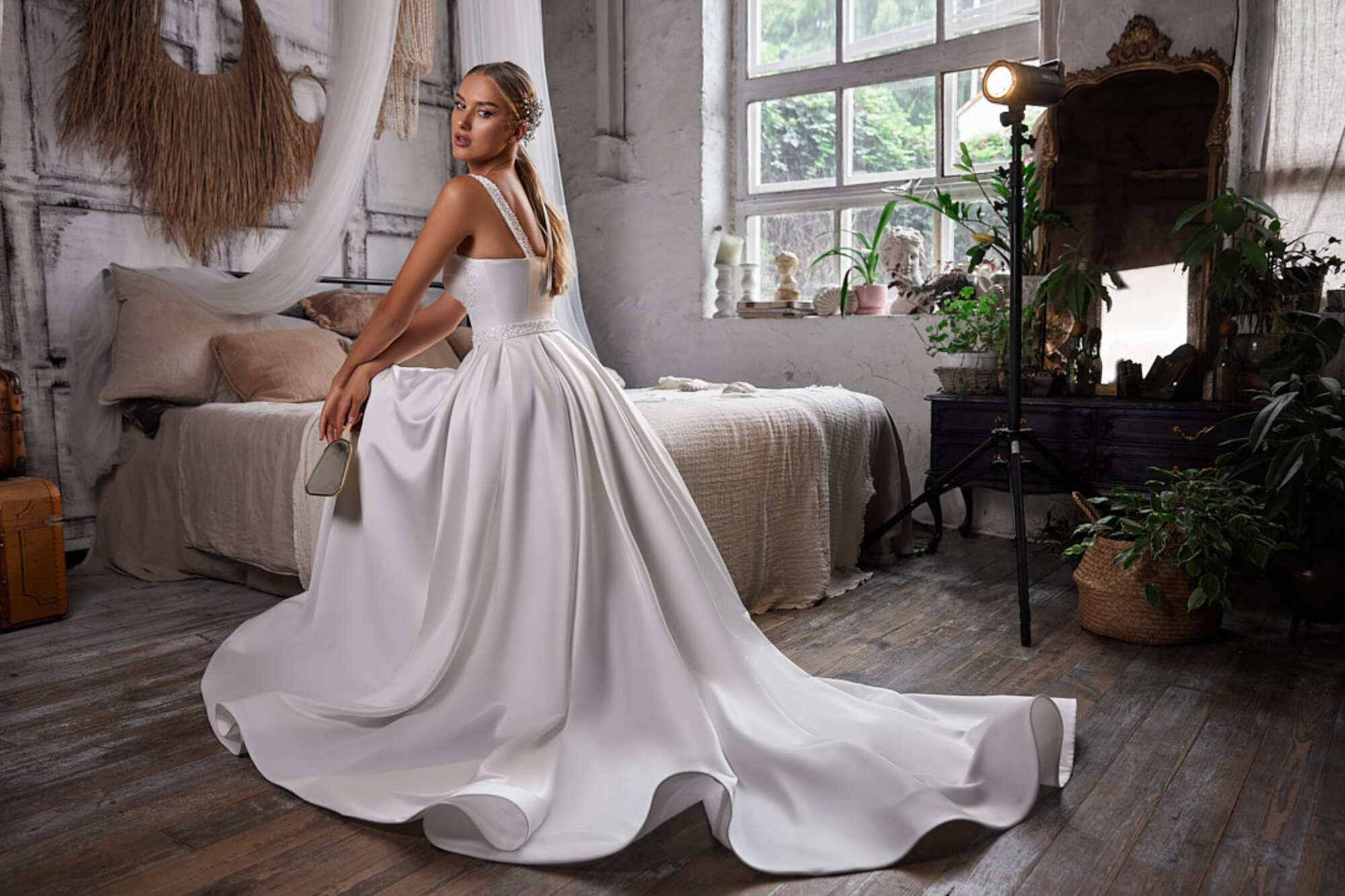 Dazzling A-line wedding dress in sleek satin, enhanced with wide beaded straps. The skirt in flared flat pleats.