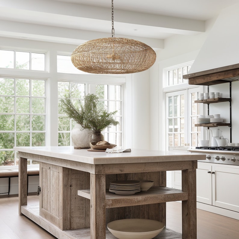 A stunning rattan pendant light is hung above a wooden farmhouse style kitchen island and 2 rustic flower vase