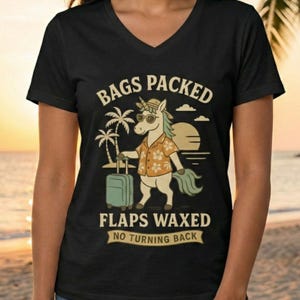 May include: Black V-neck t-shirt featuring a cartoon unicorn in sunglasses and a Hawaiian shirt, holding a suitcase. Text reads "BAGS PACKED, FLAPS WAXED, NO TURNING BACK". The background shows palm trees and a sunset.