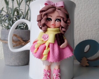 A cup with polymer clay decor, a doll on a mug, a gift cup