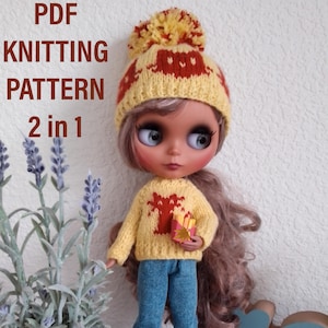 May include: A yellow and red knitted hat with a pom pom on top and a matching yellow sweater with a red tree design. The hat and sweater are for a doll.