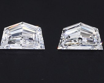 May include: Two clear, faceted, octagonal-shaped gemstones with a pointed top, set against a black background.