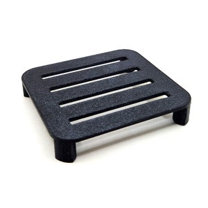 May include: A black plastic platform with five horizontal slats. The platform has four legs and is designed to elevate objects.