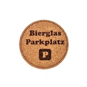 May include: A round cork coaster with the text "Bierglas Parkplatz" and a "P" symbol in the center.