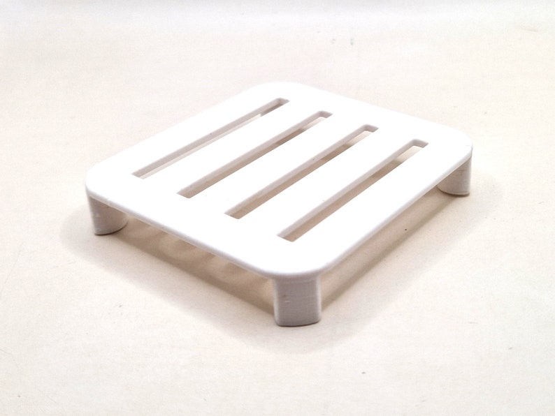 May include: White plastic shelf with five horizontal slats. The shelf has four legs.