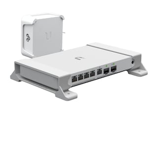 Könnte beinhalten: Ein weißer Netzwerkswitch mit sechs Ports und einem Netzteil. Der Switch hat ein kleines Logo auf der Vorderseite und ist auf einem Ständer montiert.