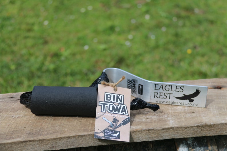 Puede incluir: Una herramienta de remolque de contenedor negra y plateada con un mango de espuma negra y una etiqueta de papel marr&oacute;n que dice "Bin Towa" y "Eagles Rest".