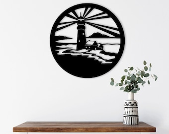 May include: Black metal wall art featuring a lighthouse with a house and sun rays in a circular frame. The art is hanging on a white wall above a wooden console table with two woven baskets.