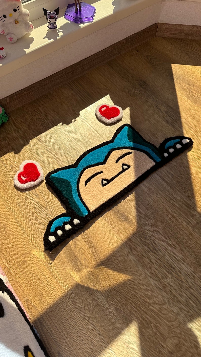 Tufted handmade rug with kawaii sleepy creature design, blue ears and sweet paws peeking from below, surrounded by red hearts. Plush soft pile adds fluffy cozy feel. Perfect as anime rug, cartoon carpet, or kawaii rug décor. Unique handmade rug gift for couples or friends. Adds cheerful cozy charm to bedrooms, nurseries, or creative spaces. Cute rug for playful romantic modern décor