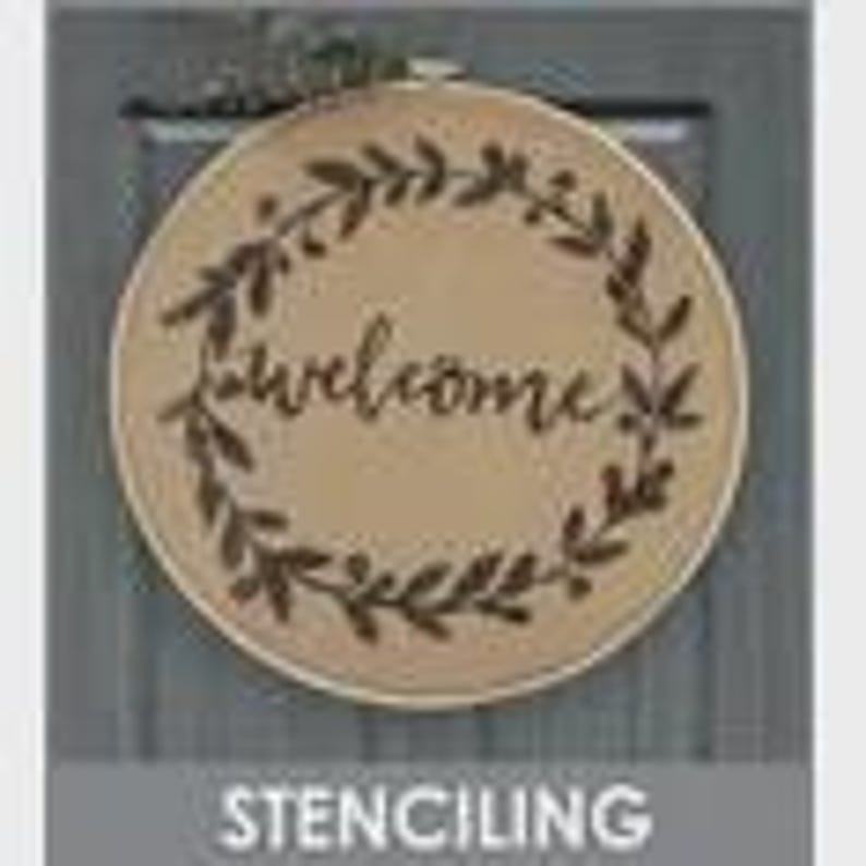 May include: Round wooden sign with the word "welcome" in cursive script, surrounded by a wreath of leaves. The sign is mounted on a gray background. The word "STENCILING" is at the bottom of the image.