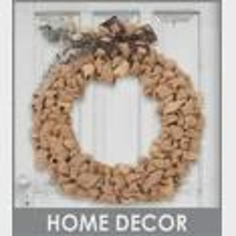 May include: A round wreath made of natural-colored materials, possibly wood or bark, with a decorative bow at the top. The wreath is hanging on a white door. The text "HOME DECOR" is at the bottom.