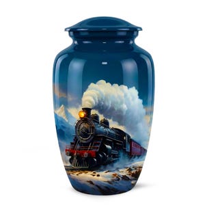 Könnte beinhalten: Marineblaue Urne mit glänzender Oberfläche. Sie zeigt eine gemalte Szene eines alten Dampfzuges, der durch eine verschneite Berglandschaft fährt, mit weißem Rauch und hellem Scheinwerfer.