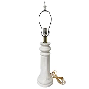 May include: A white ceramic table lamp with a fluted column base and a decorative top. The lamp has a black harp and a gold-colored socket. The lamp is approximately 18 inches tall.