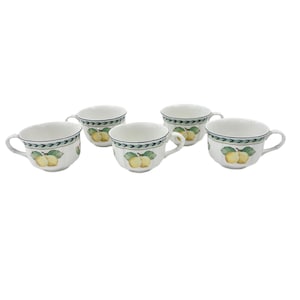May include: Five white teacups with a lemon design. Each cup has a green and black border with a pattern of leaves and arrows. The cups are decorated with yellow lemons and green leaves.
