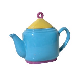 May include: A ceramic teapot with a light blue body, a yellow lid, and a pink handle and base. The teapot has a curved spout and a rounded handle. The lid has a small, pink circular handle. The teapot is designed with a modern, colorful aesthetic.