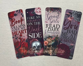 Può includere: Quattro segnalibri con disegni floreali scuri e immagini di teschi. I segnalibri presentano il seguente testo: "Book Villains Have My Heart", "I Like My Romance On The Dark Side", "Good Girls Read Dark Romance", e "You Had Me At Trigger Warning".
