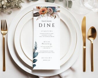 Op de afbeelding: Een huwelijksmenukaart met een bloemmotief. De kaart heeft de tekst "Diana & Alexander" en "DINE" in vetgedrukte letters. Het menu bevat voorgerechten, hoofdgerecht en dessert.
