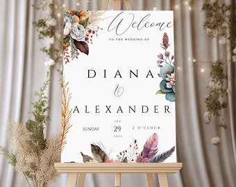 May include: Welcome to the wedding of Diana & Alexander, a wedding sign with floral and feather accents, set on an easel. The wedding is on Sunday, September 29th, 2024 at 2 o'clock.