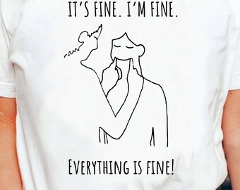 May include: White t-shirt with a black line drawing of a person covering their mouth with their hand. The text "It's fine. I'm fine. Everything is fine!" is printed on the shirt.