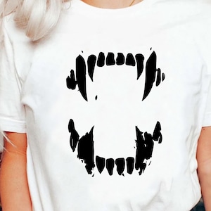 May include: White t-shirt with a black graphic of a set of fangs.