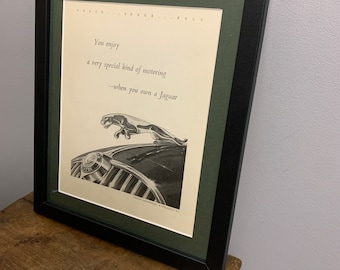 May include: A framed black and white print of a Jaguar car with the text "You enjoy a very special kind of motoring -when you own a Jaguar".