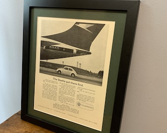 May include: A vintage black and white advertisement for the Volkswagen Beetle. The ad features a photo of a Volkswagen Beetle driving on a road with a large airplane wing in the background. The text reads "The Beetle got there first." and includes information about the car's features and price.