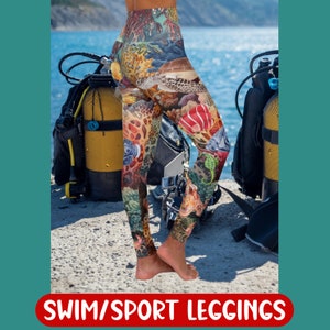 Op de afbeelding: Een paar kleurrijke leggings met een duikthema. De leggings bevatten verschillende zeedieren, waaronder zeepaardjes, zeesterren en een octopus. De leggings worden getoond tegen een achtergrond van duikuitrusting.