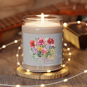 May include: A brown glass candle with a floral design and the text "His mercies are new every morning" with the scripture reference "Lamentations 3:23".