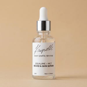 Può includere: Un flacone contagocce in vetro trasparente contenente siero per barba e pelle. L'etichetta bianca riporta il testo Vimpelle, scent profile: Minimal, SQUALANE + MCT BEARD & SKIN SERUM, 30ml e Made in Lithuania. Ha un collare argento e tappo bianco.