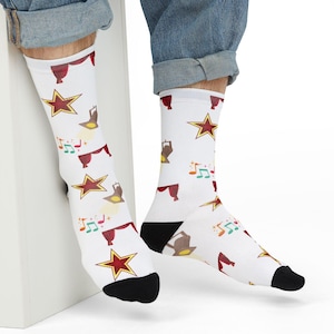 May include: White socks with a red star, musical notes, and a spotlight design. The socks are worn by a person wearing blue jeans.