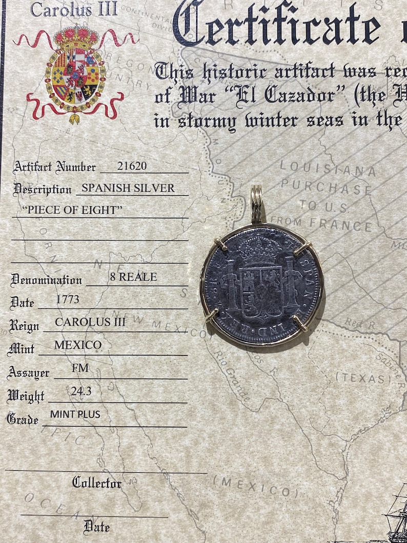 May include: A certificate of authenticity for a Spanish silver "Piece of Eight" coin, dated 1773. The coin is 8 reales and was minted in Mexico during the reign of Carolus III. The certificate includes the coin's artifact number, denomination, date, reign, mint, assayer, weight, and grade. The coin is pictured on the certificate.