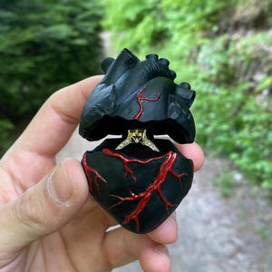 Anatomisches Herz Ringkästchen mit schwarzem Kissen und Ständer.