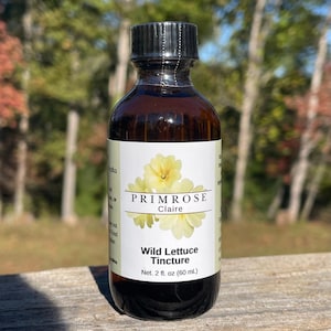 Puede incluir: Una botella de vidrio marrón con una tapa negra y una etiqueta blanca. La etiqueta dice "PRIMROSE Claire Wild Lettuce Tincture Net. 2 fl. oz (60 ml.)"