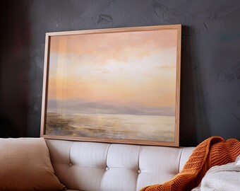 May include: A framed painting of a seascape with a soft, golden sunset over the water. The painting is in a light wood frame and is hanging on a dark gray wall.