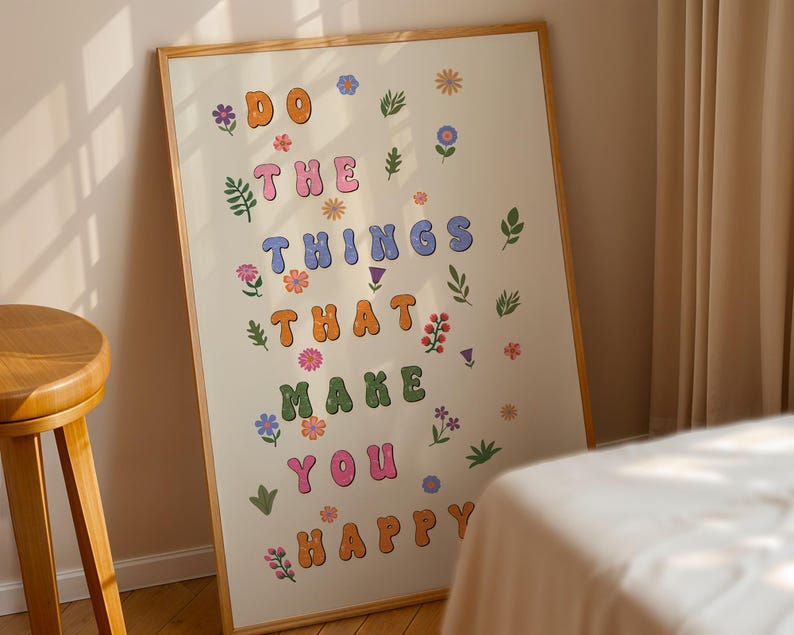 May include: A framed print with a white background and colorful letters that read "Do the things that make you happy". The letters are surrounded by small floral illustrations.