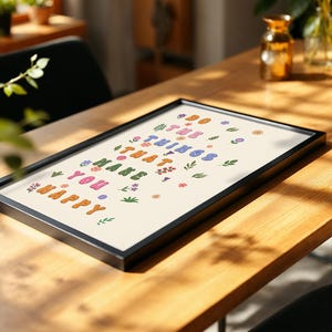 May include: A framed print with a white background and colorful text that reads "Do the things that make you happy". The text is surrounded by small, colorful flowers.