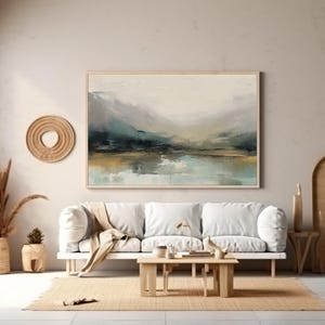 May include: A white sofa with a throw blanket sits in a living room with a large abstract landscape painting on the wall. The painting features shades of blue, green, and brown. The room is decorated in a minimalist style with a wooden floor and a woven rug.
