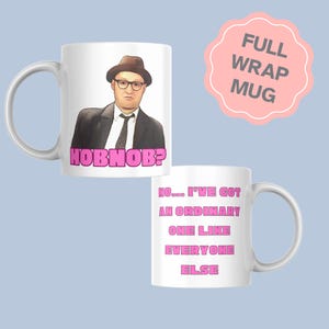 May include: A white ceramic mug featuring a graphic of a person wearing a brown hat, glasses, and a suit, with the pink text HOBNOB? below. The reverse side displays the pink text NO... I'VE GOT AN ORDINARY ONE LIKE EVERYONE ELSE.
