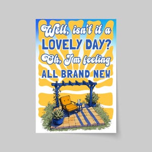 May include: A rectangular poster featuring a yellow sunburst background and the text "Well, isn't it a LOVELY DAY? Oh, I'm feeling ALL BRAND NEW". Below, a blue pergola shades an orange chair, a small side table with a drink, and a potted plant.
