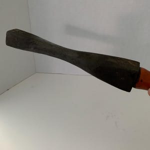 May include: A wooden tool with a dark brown finish and a rounded handle. The tool has a flat, rectangular head.