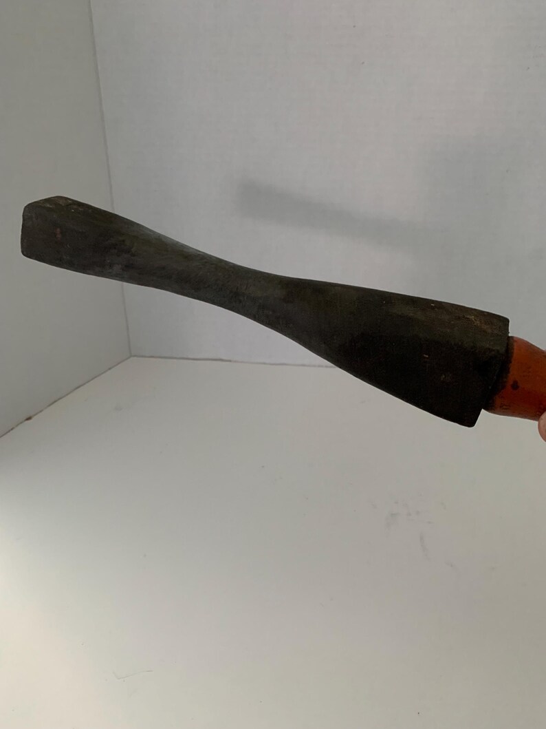 May include: A wooden tool with a dark brown finish and a rounded handle. The tool has a flat, rectangular head.