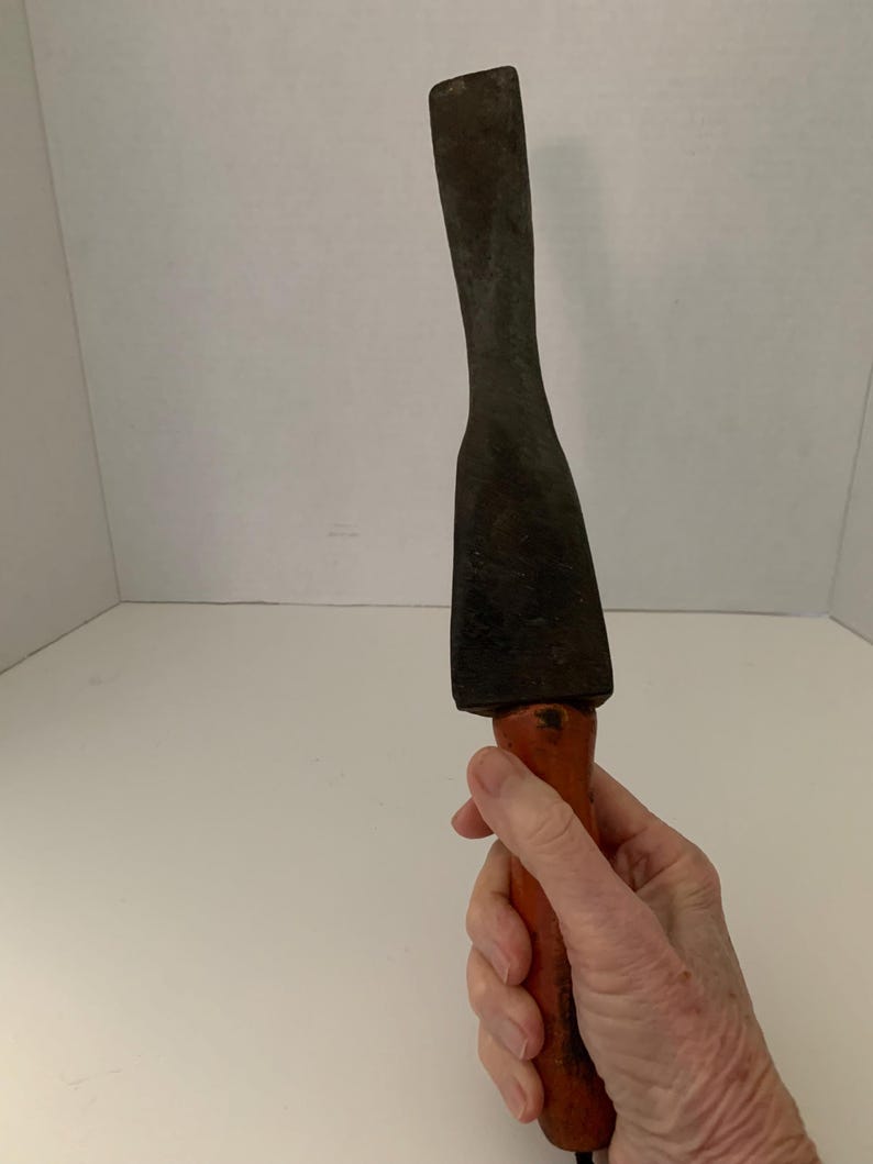 May include: A vintage wooden-handled metal chisel with a flat blade. The chisel is rusty and has a worn wooden handle.