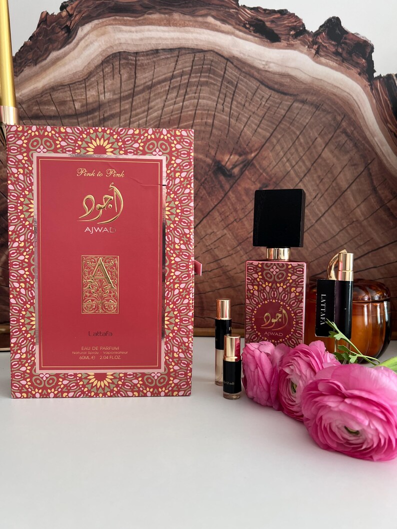 K&ouml;nnte beinhalten: Ein Parf&uuml;mset mit einer roten Schachtel und Flasche, goldenen Details und dem Text "AJWAL" und "Lattafa". Das Set enth&auml;lt kleine Fl&auml;schchen und rosa Blumen. Auf der Schachtel steht "Pink to Pink" und "EAU DE PARFUM 60ml".