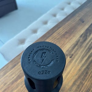 May include: Black plastic electrical outlet cover with the text "Current Innovations LLC" and a lightning bolt logo. The cover has a number "0320" printed on it.