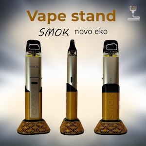 Peut inclure: Un support de vape dor&eacute; et noir avec une base g&eacute;om&eacute;trique, tenant un stylo vape argent&eacute; et noir. Le texte "Vape stand" et "SMOK novo eko" est affich&eacute;. Le support est con&ccedil;u pour un appareil de vape.
