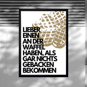May include: A black and white poster with a gold waffle graphic and the text "Lieber einen an der Waffel haben, als gar nichts gebacken bekommen".